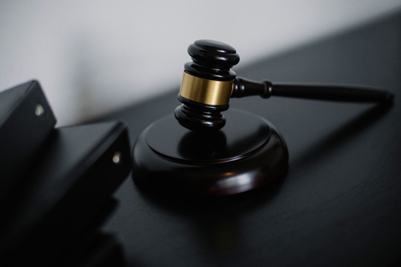 about-us High angle of shiny wooden ceremonial mallet with golden detail placed on judge tale near documents folders